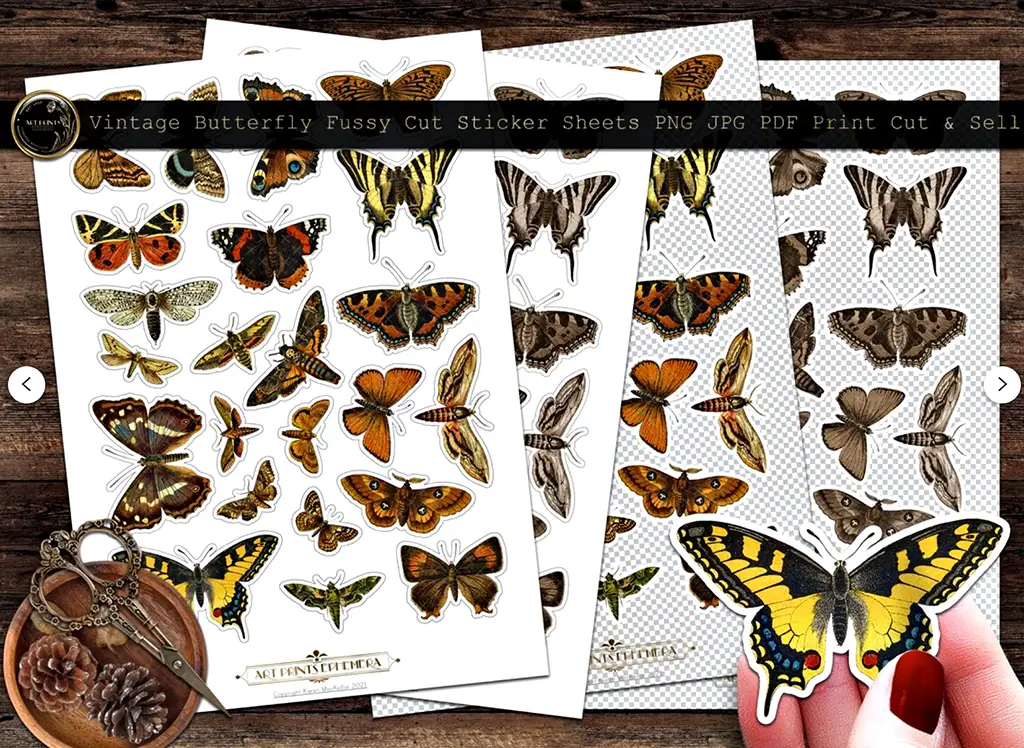 Various sheets of fussy cut stickers featuring vintage butterflies are displayed on a wooden surface. Each sheet showcases butterflies of different sizes and colors, arranged neatly. A person's hand holding a large yellow and black butterfly cutout is visible at the bottom right.