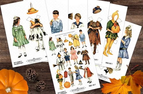 A flat lay of six sheets featuring vintage-style cut-out paper dolls in various costumes, including animals, fairy tale characters, and Halloween-themed outfits. A small pumpkin, pine cones, and autumn leaves adorn the wooden background.
