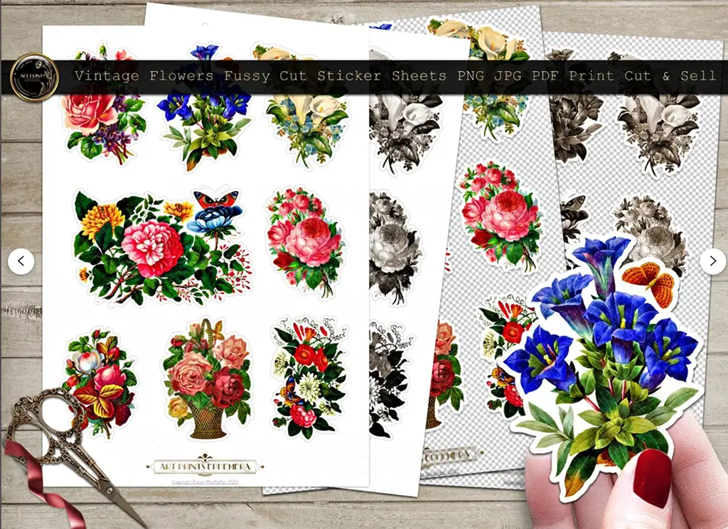 A charming display of vintage flower sticker sheets, showcasing colorful floral designs like roses, butterflies, and blue lilies. The sheets rest elegantly on a wooden surface alongside scissors and a hand holding delicate fussy cut ephemera from the stickers.